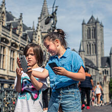 twee kinderen met smartphone op de Sint-Michielsbrug