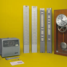 Pièce d'horlogerie de la marque Amano avec carte en métal et horloge maîtresse dans un coffret en bois. Provient de l'imprimerie Strobbe à Izegem, vers 1950-1975.