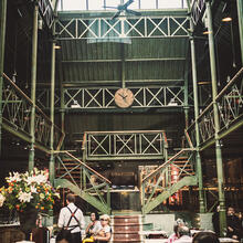 restaurant met hoge plafond in staal en glas met een centrale trap