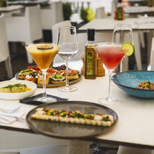 Tafel op het terras met daarop verschillende gerechten en twee cocktails