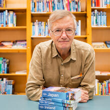 Tony Wheeler met verschillende Lonely Planet boeken in Gent