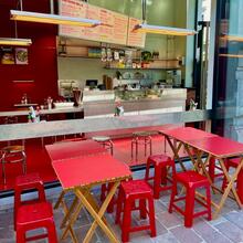terras met rode stoelen en tafels voor het grote raam van het restaurant