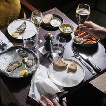 Tafel met witte borden met oesters en champagne
