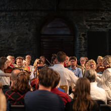 Sfeerbeelden Lauden 2023: een intiem strijkersorkest wordt omringd door het aanwezige publiek in de historische refter van de Sint-Baafsabdij