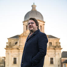 Le professeur Steven Vanderputten pose devant l'église Saint-Pierre sur la place Saint-Pierre à Gand