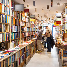 2 personen staan te kijken naar een kast vol boeken