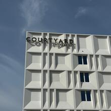 Witte buitengevel van het hotel met een blauwe lucht op de achtergrond 