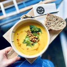 Kom soep op een tafel met stuk brood