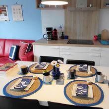 Open ruimte met zitgedeelte links en keuken met tafel rechts